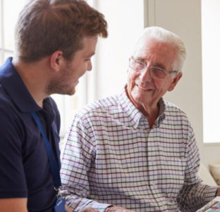 A carer listening to an older gentleman