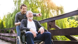 A carer taking an older gentleman outside