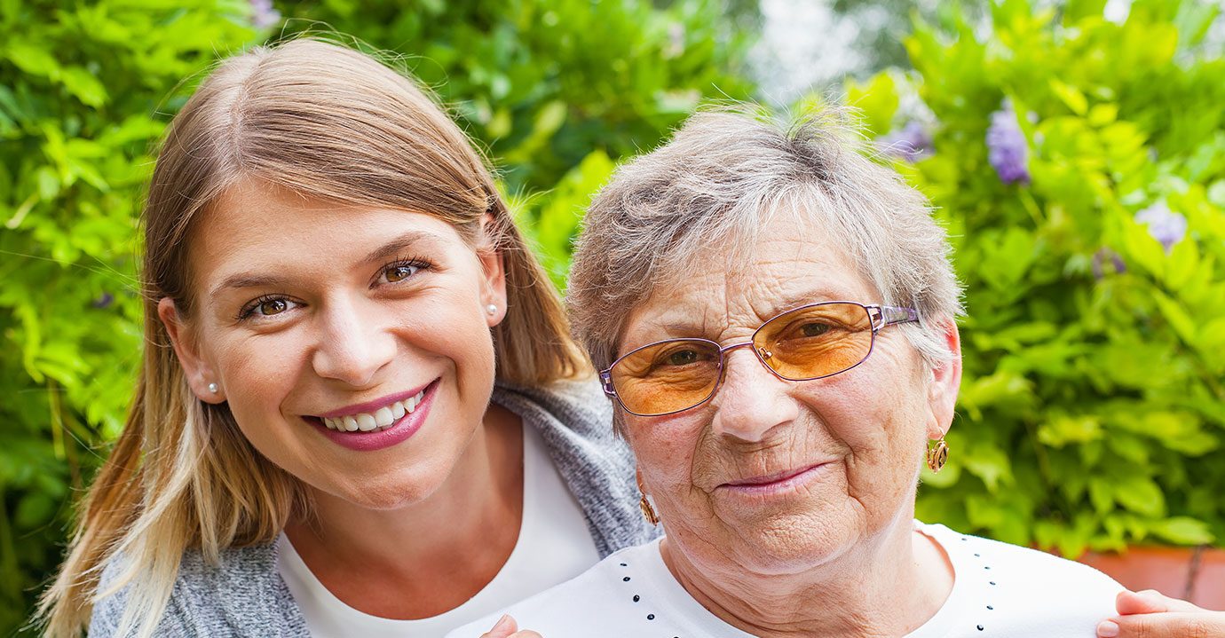 Two ladies close together smiling at the camera