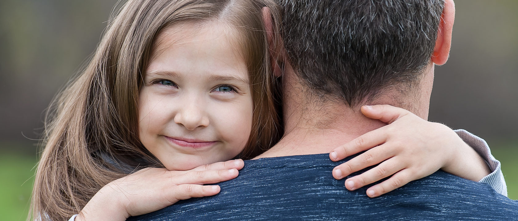 A girl having a hug from her dad